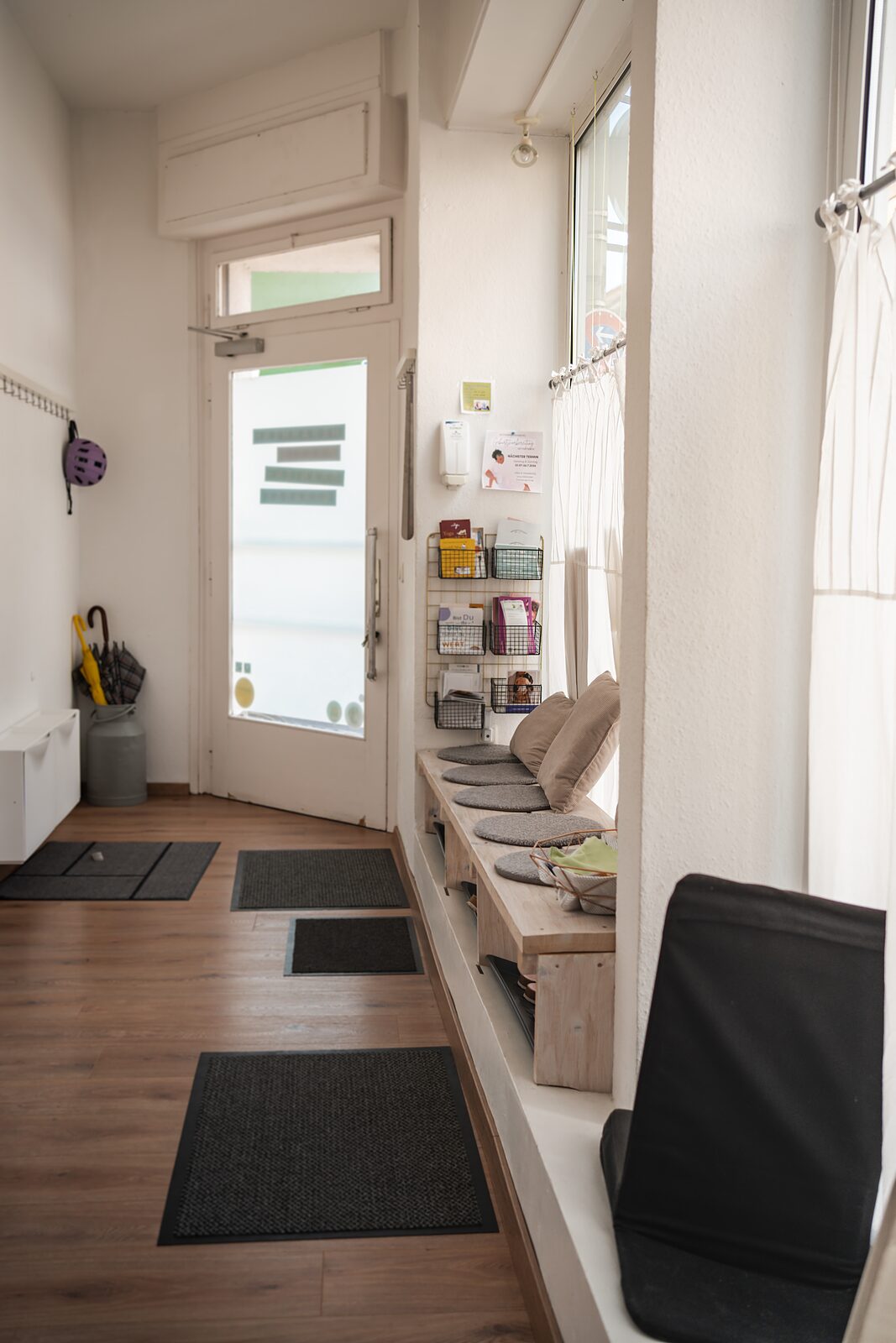 Wartebereich mit Sitzbank und Kissen am Fenster